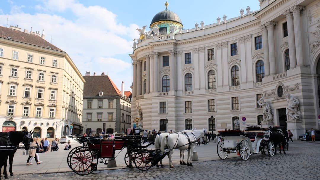 Wiedeń, fiakry z końmi przed Pałacem Hofburg, historyczna architektura, turystyka.