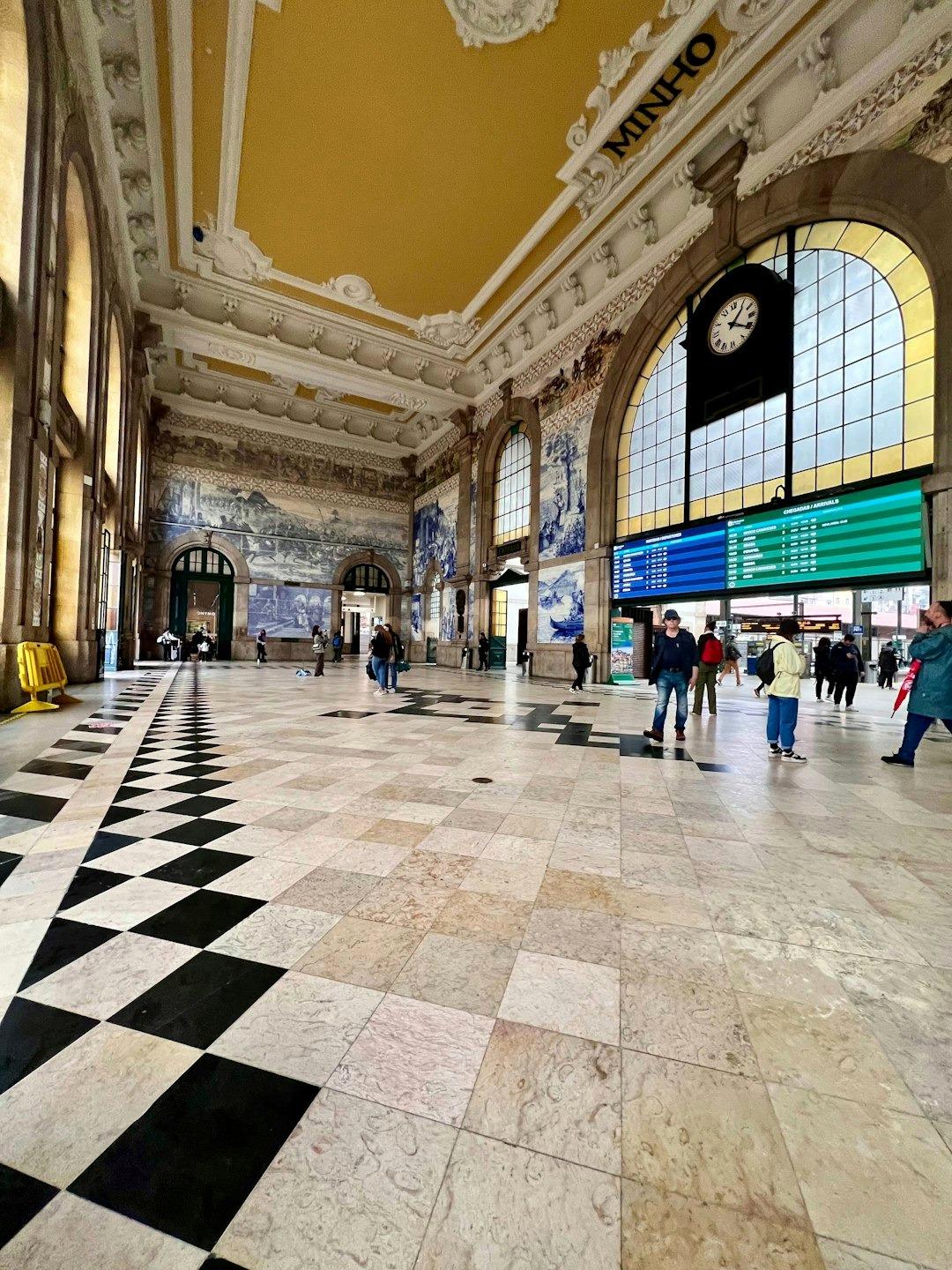 Wnętrze historycznego dworca kolejowego São Bento w Porto z azulejos i ludźmi.