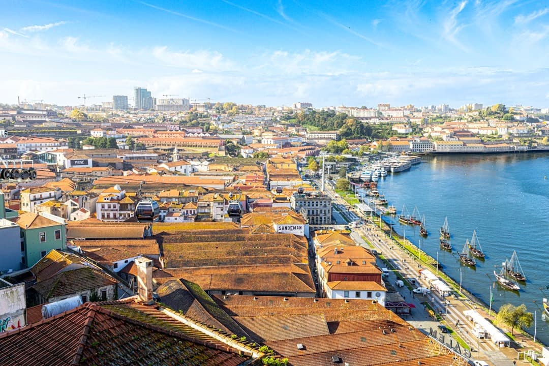 Panorama Porto, rzeka Douro, tradycyjne łodzie rabelo, czerwone dachy.