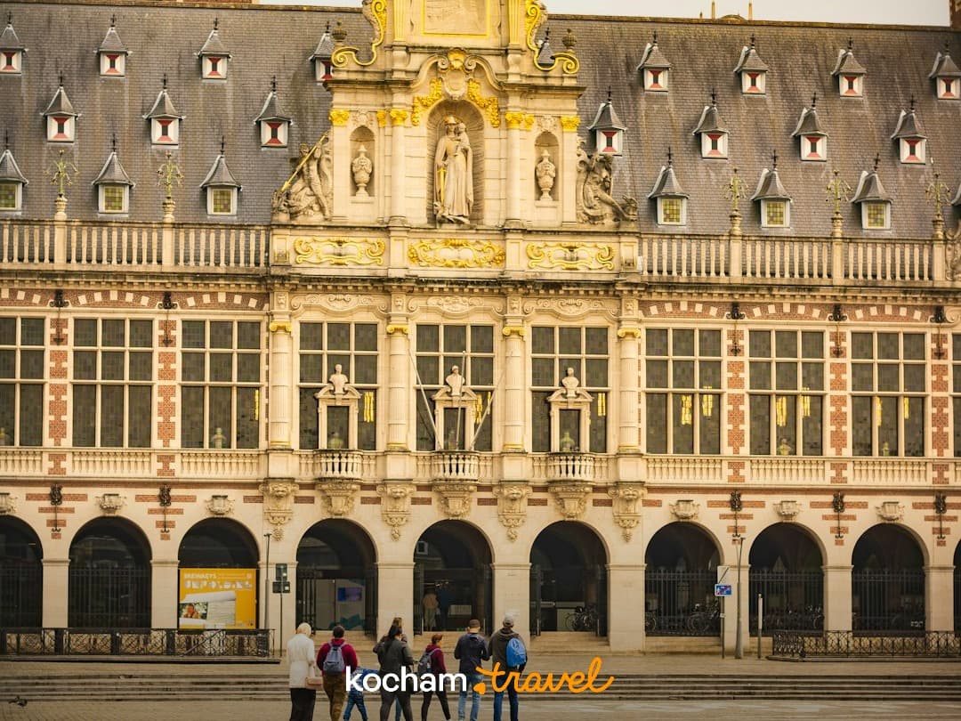 Złoty, ozdobny budynek, plac miejski, ludzie, europejska architektura.