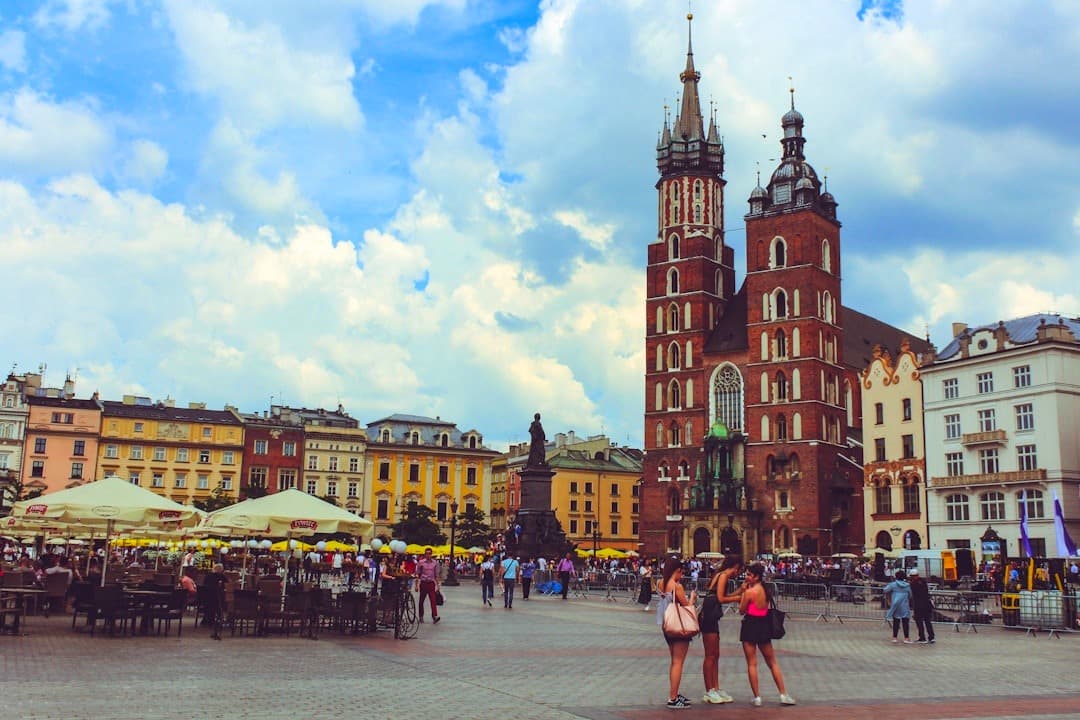 Kraków Rynek Główny, Bazylika Mariacka, historyczna architektura, turyści, plac miejski