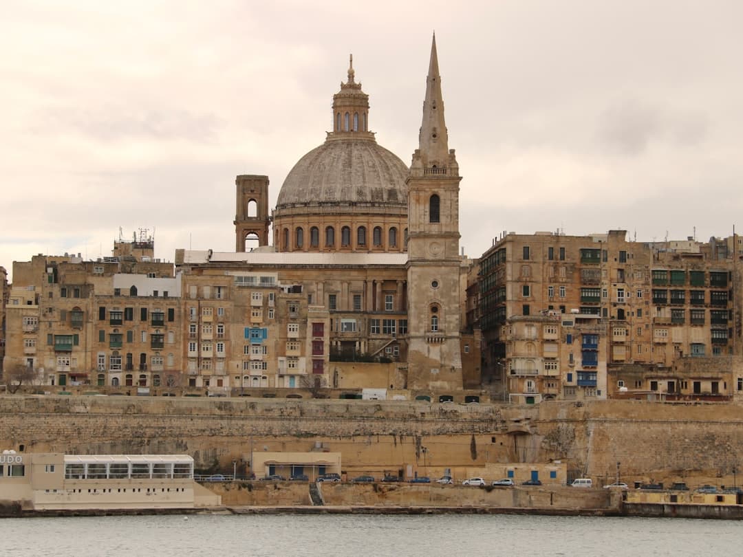 Valletta, Malta: Katedra św. Pawła, kopuła, wieża, zabytkowe kamienice nad wodą.
