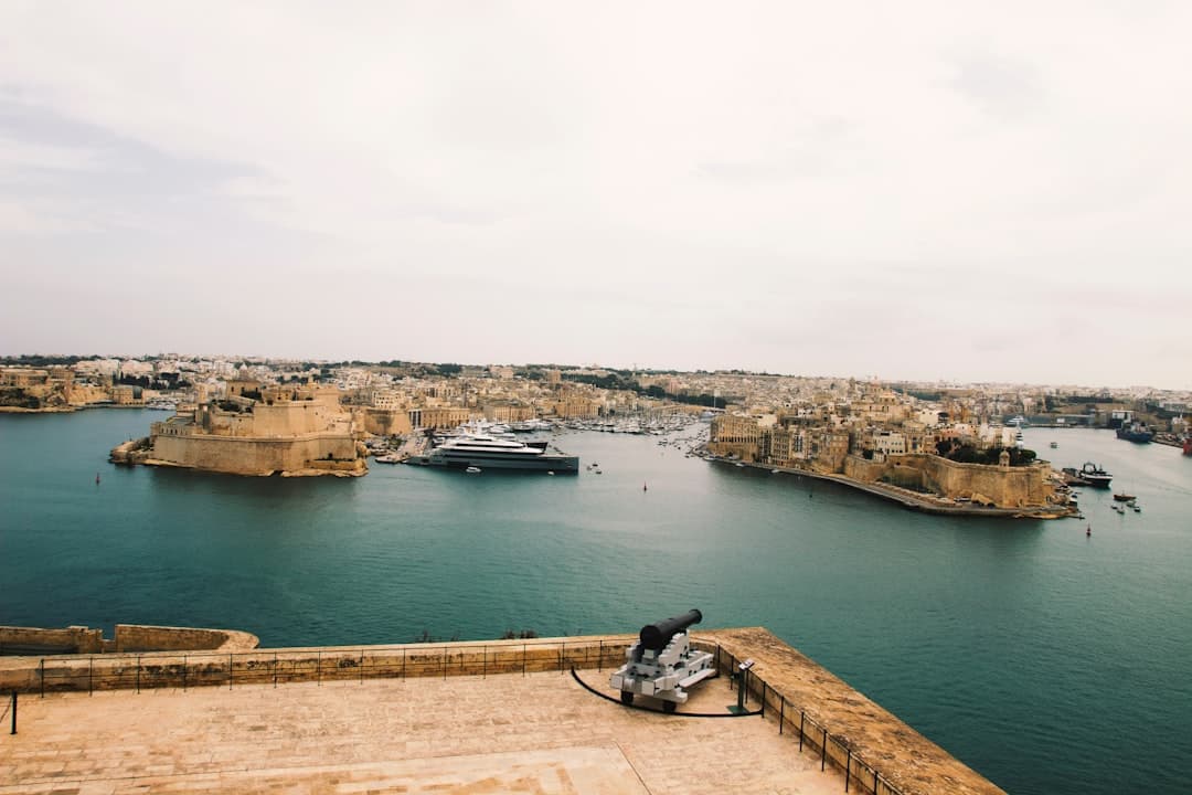 Malta, widok na historyczny port, fortyfikacje, jacht i miasto.