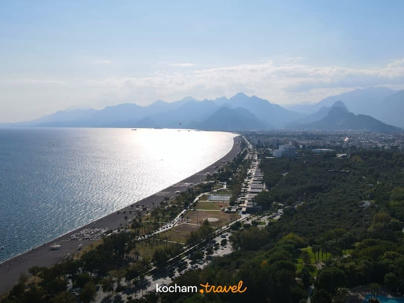 Panoramiczny widok na wybrzeże, plażę, morze, miasto i góry.