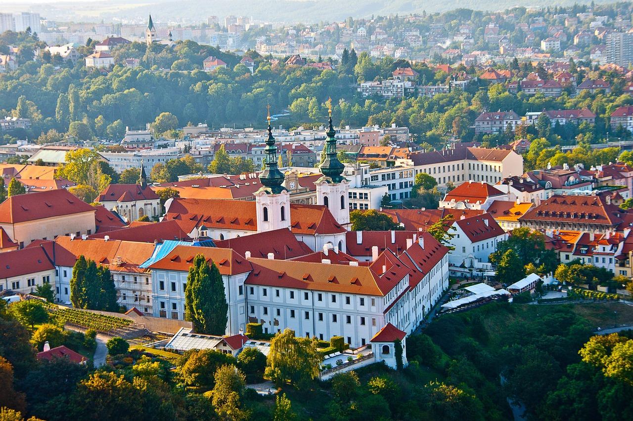 Panoramiczny widok na historyczne miasto z klasztorem i czerwonymi dachami.