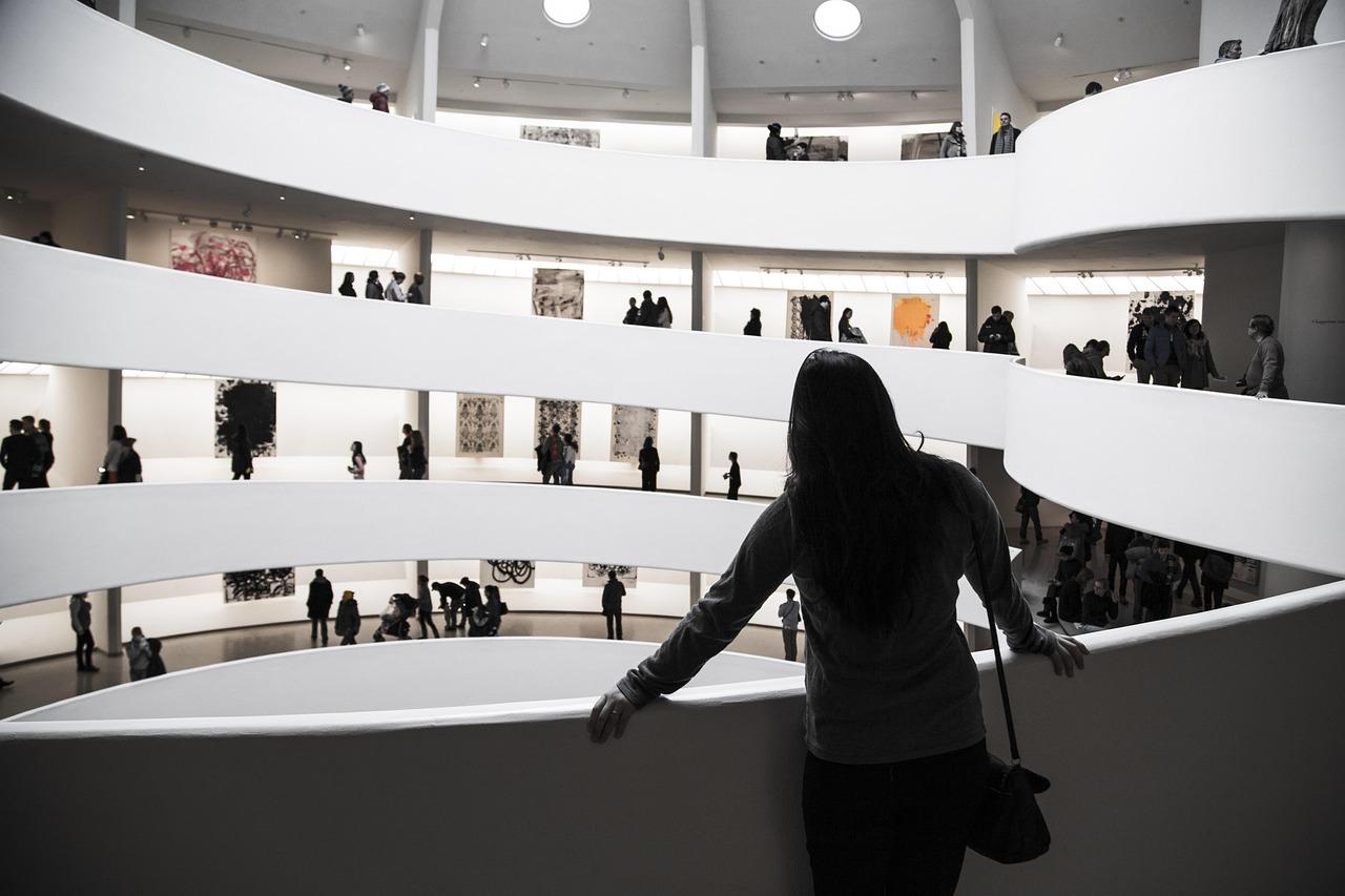 Spiralne wnętrze muzeum sztuki z wieloma zwiedzającymi i wystawami.