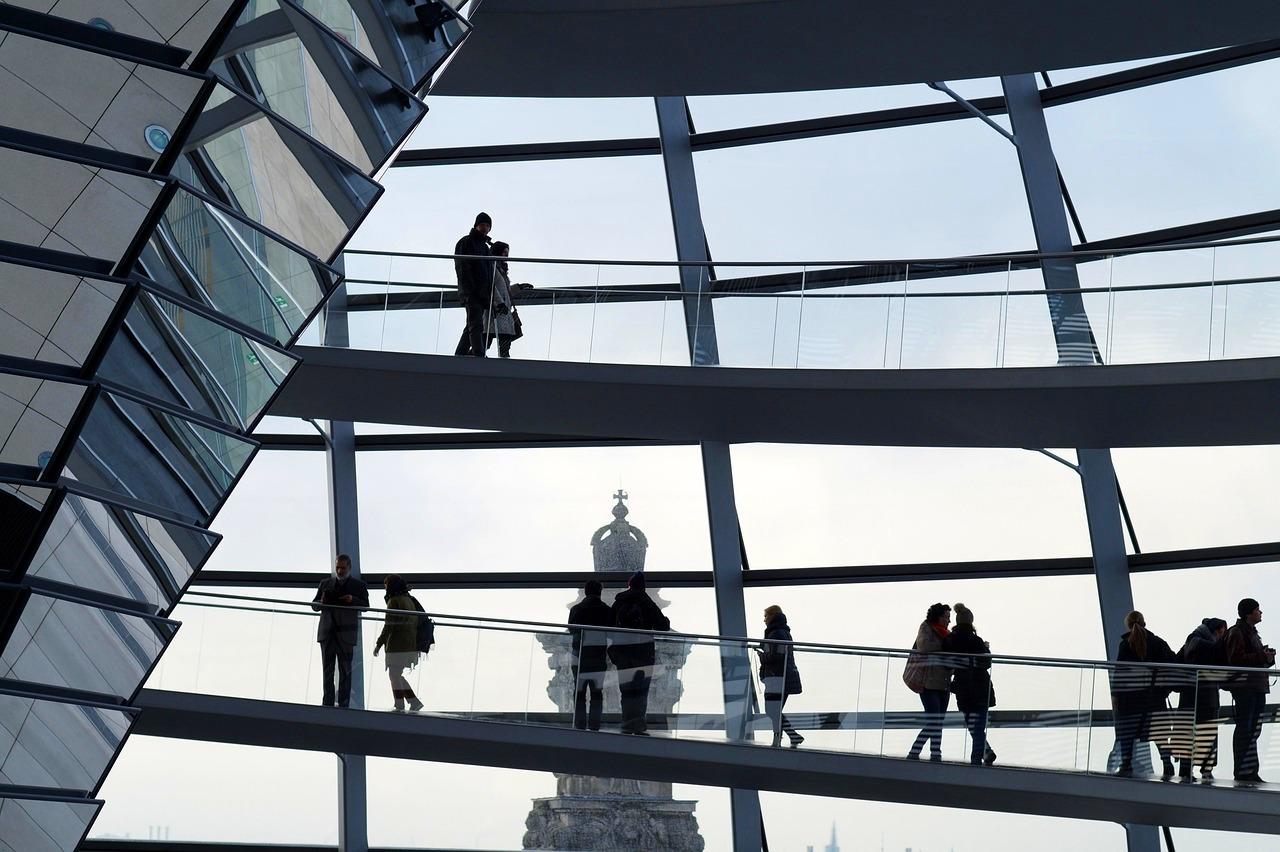 Zwiedzający kopułę Reichstagu w Berlinie, nowoczesna architektura, szklane rampy.