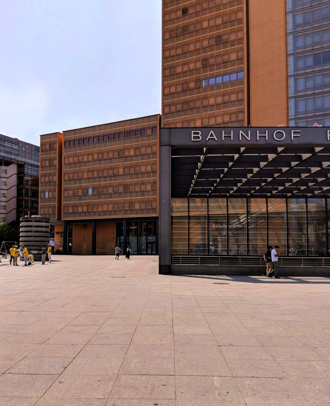 Nowoczesny budynek dworca "Bahnhof" na placu miejskim w słoneczny dzień.