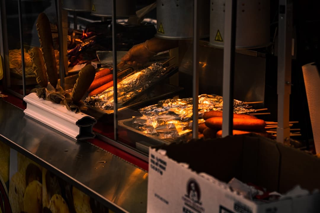 Stoisko z gorącymi hot dogami, parówkami kukurydzianymi i innymi przekąskami.