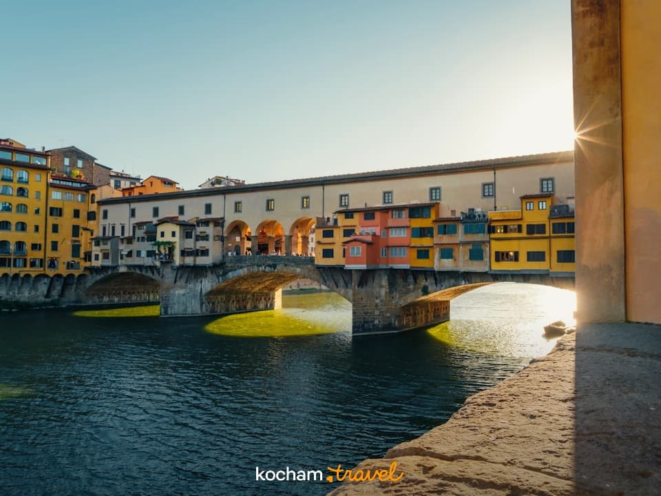 Florencja: historyczny most Ponte Vecchio, rzeka Arno, ciepłe światło.