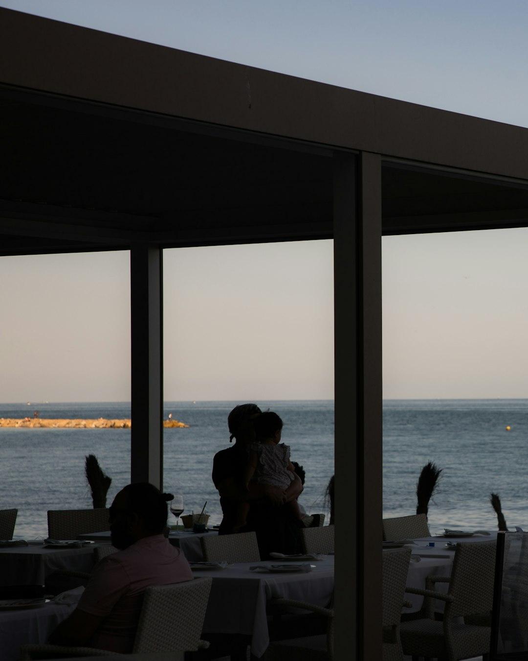 Rodzinna kolacja w restauracji nad morzem o zachodzie słońca.