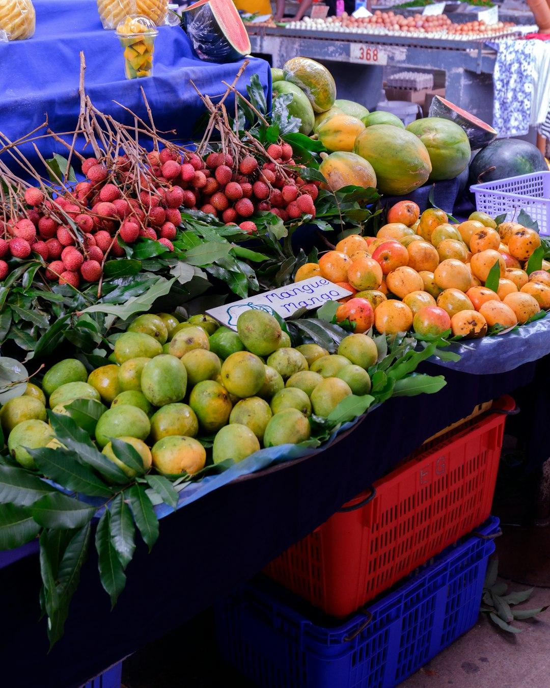 Kolorowy stragan z egzotycznymi owocami: liczi, mango, papaja.