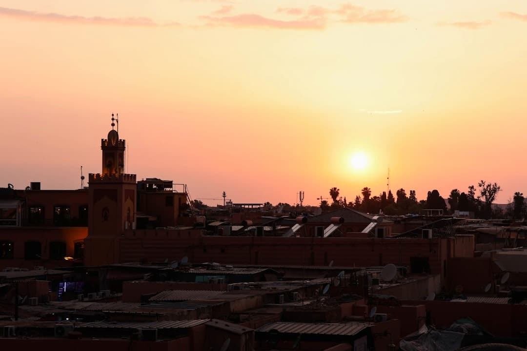 Marokański zachód słońca nad miastem, minaret meczetu, żywe niebo.