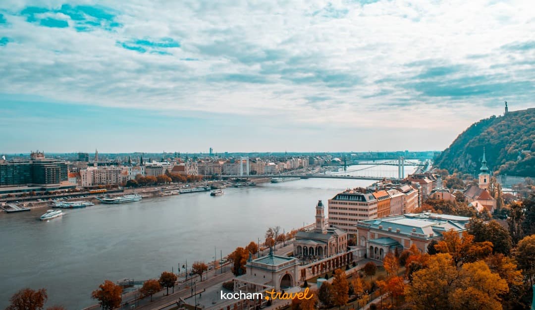 Panorama Budapesztu z Dunajem, mostami, zabudową i jesiennym wzgórzem.