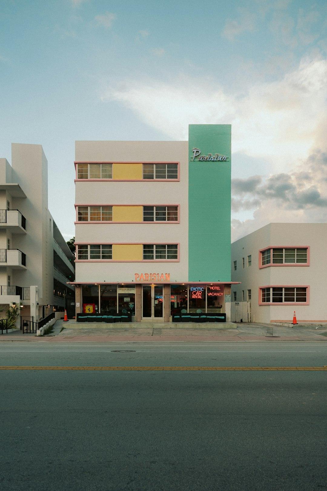 Budynek Art Deco w pastelowych kolorach, neonowy szyld hotelu.
