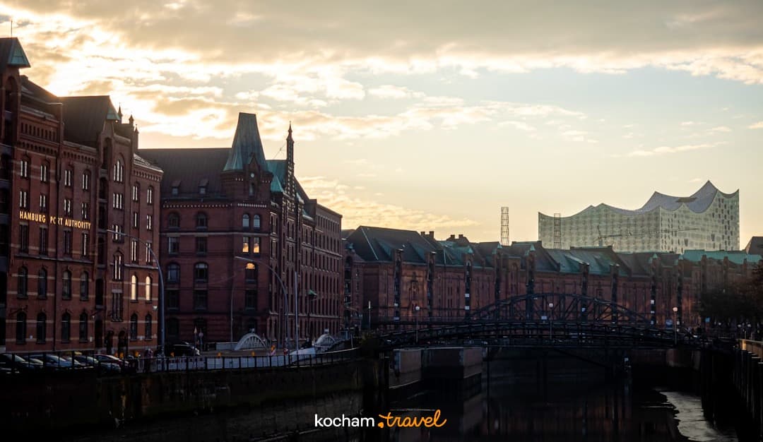 Hamburg Speicherstadt Elbphilharmonie, kanał, most, ceglana architektura, ciepłe światło.