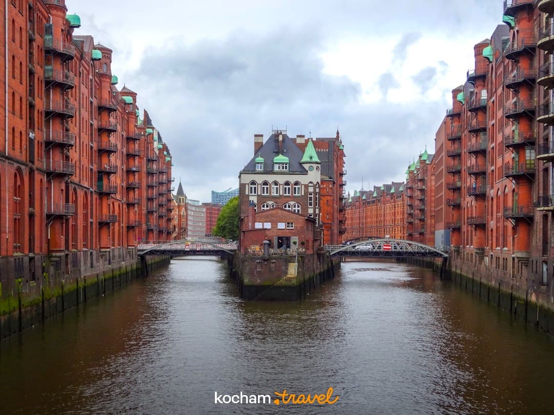 Ceglane budynki Speicherstadt w Hamburgu, kanał i mosty.