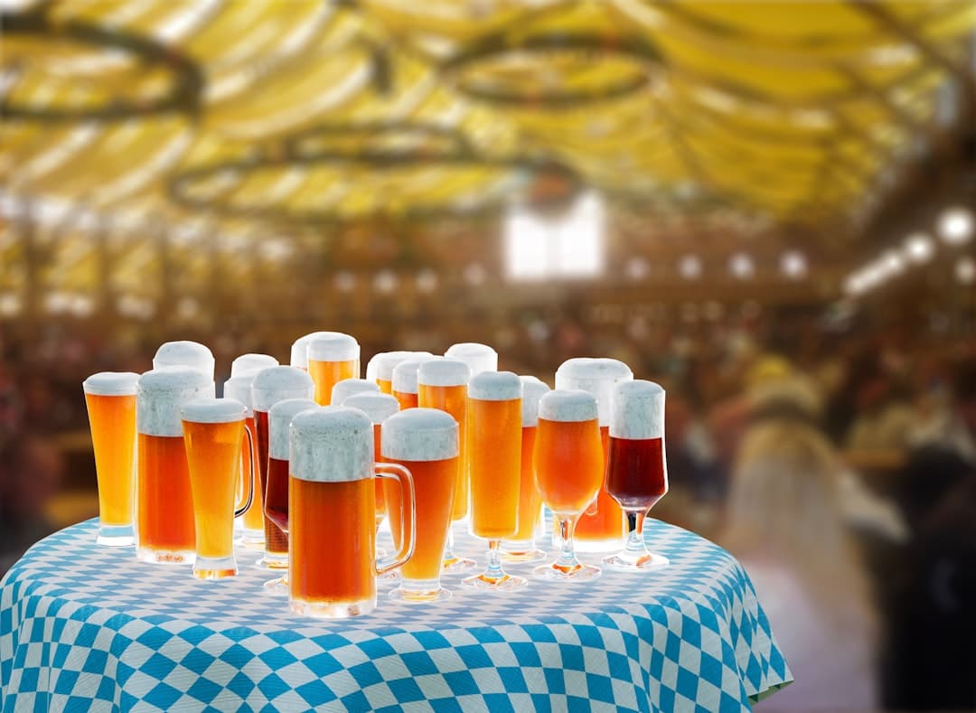 Różne piwa w kuflach na stole w kratę na imprezie festiwalowej.