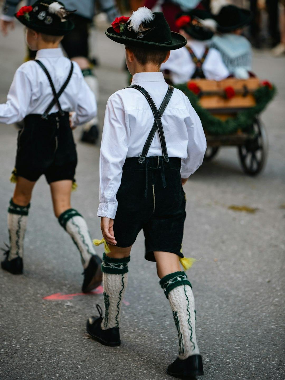Chłopcy w tradycyjnych bawarskich strojach, lederhosen i kapeluszach z piórami.