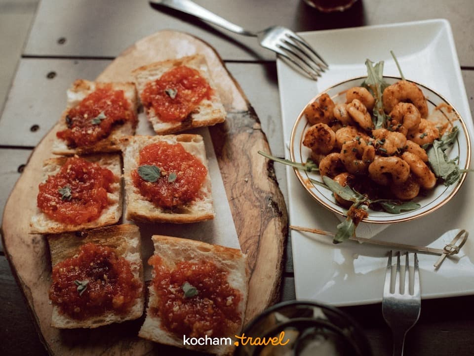 Pyszna bruschetta pomidorowa i smażone krewetki na stole.