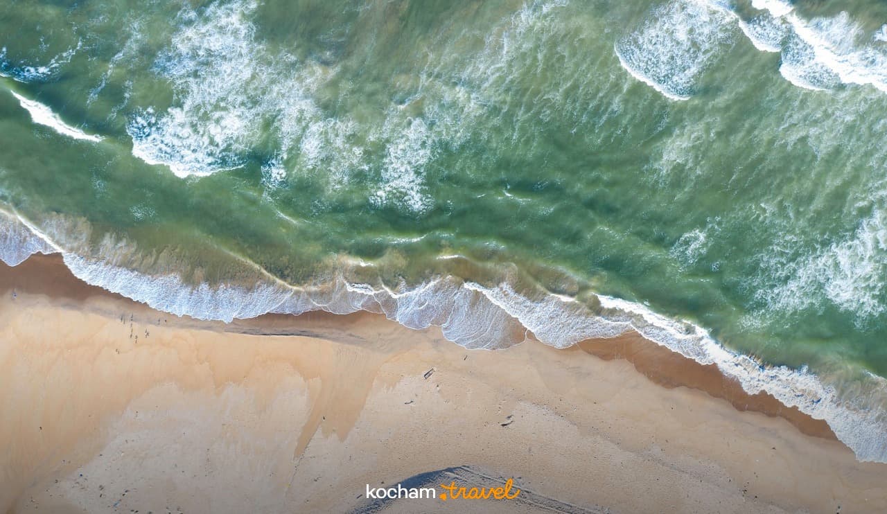 Widok z lotu ptaka na piaszczystą plażę i fale oceanu