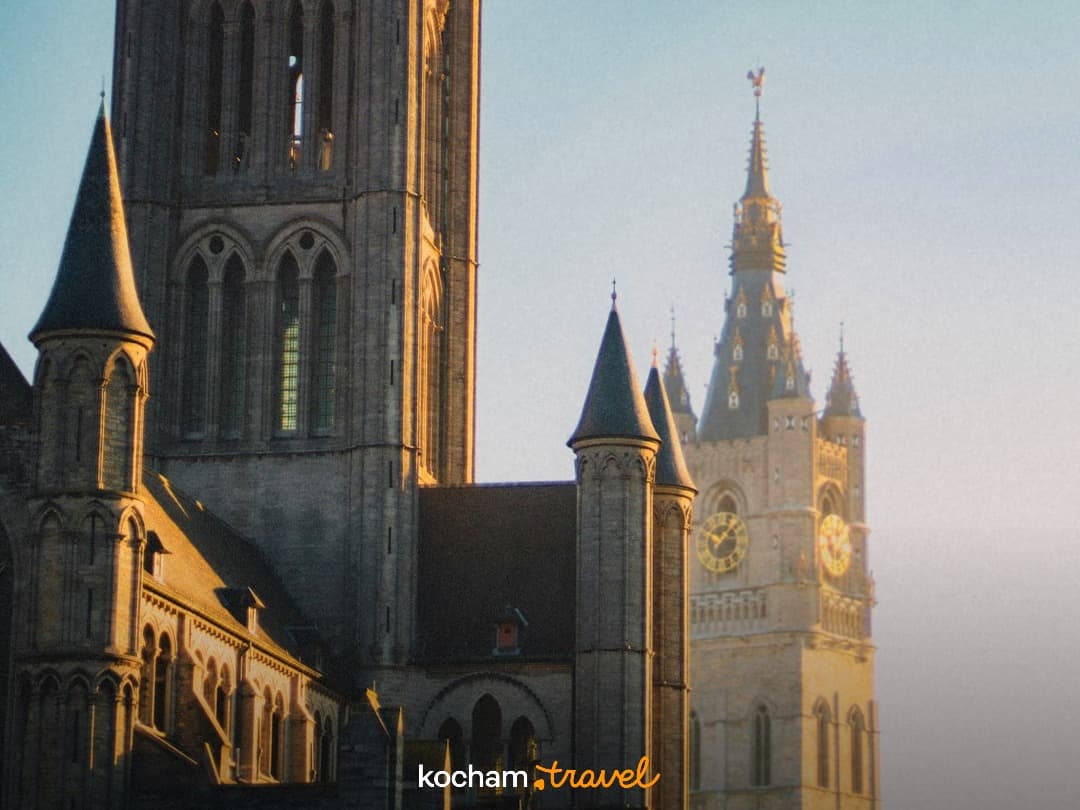 Gandawa Belgia, zabytkowe wieże, gotycka architektura, zachód słońca.