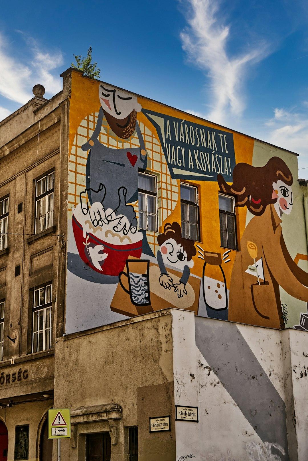 Węgierski mural przedstawiający postacie piekące chleb na ścianie kamienicy.