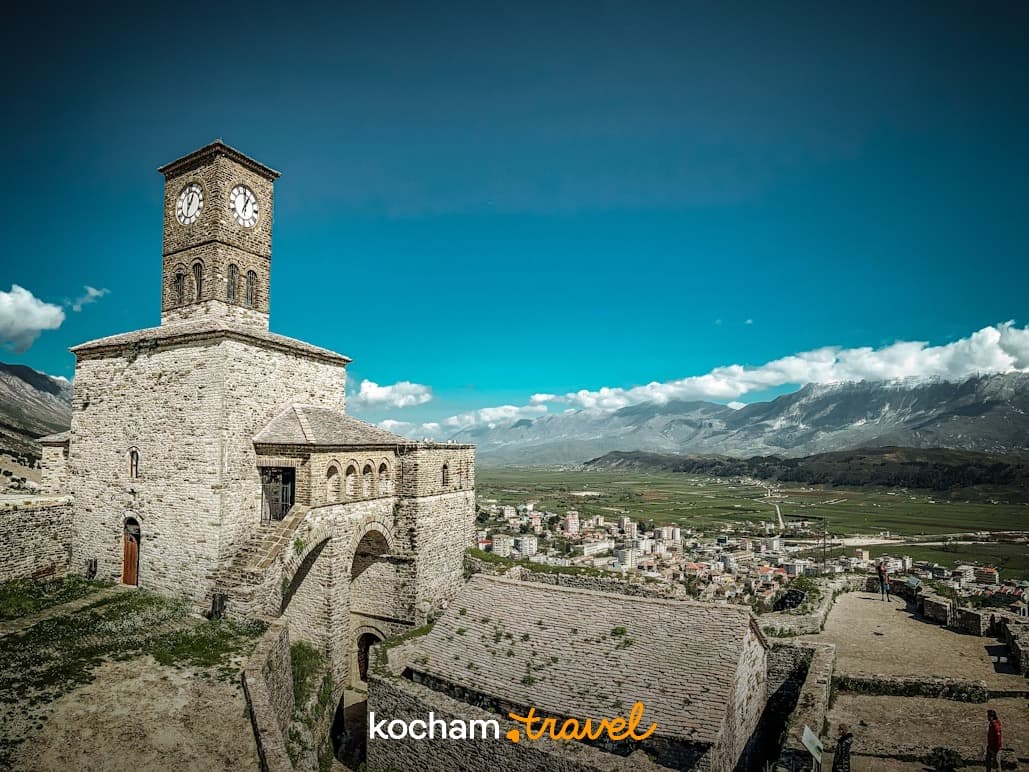 Historyczna kamienna wieża zegarowa zamku w Gjirokastrze, Albania, góry.