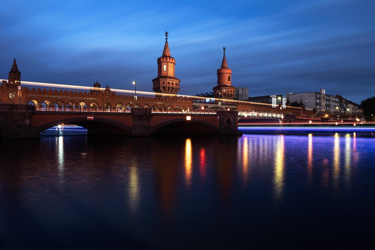 Oberbaumbrücke Berlin nocą, światła i odbicia na rzece Spree.