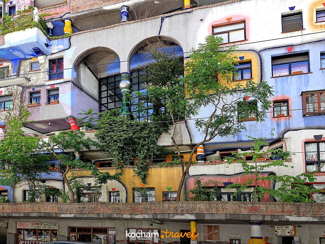 Kolorowy, unikalny budynek Hundertwasserhaus w Wiedniu z drzewami.