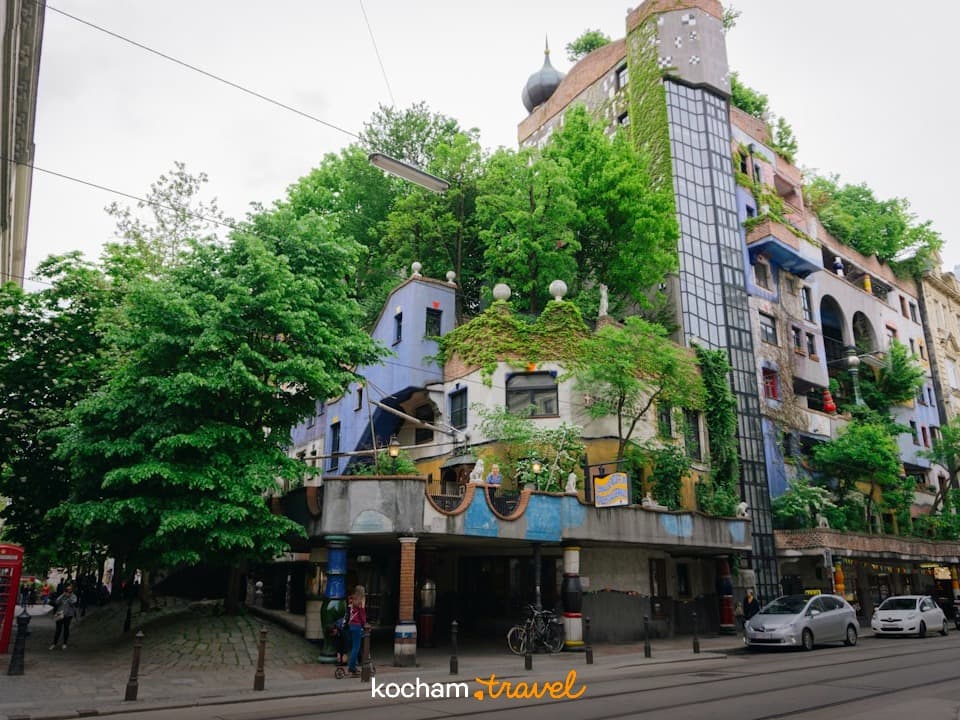 Kolorowy, unikalny budynek Hundertwasserhaus w Wiedniu, z zielonymi dachami.
