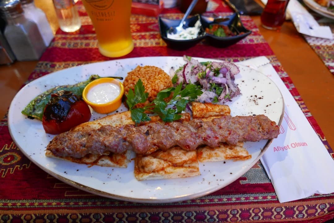 Turecki kebab z bułgurem, grillowanymi warzywami i sałatką w restauracji.