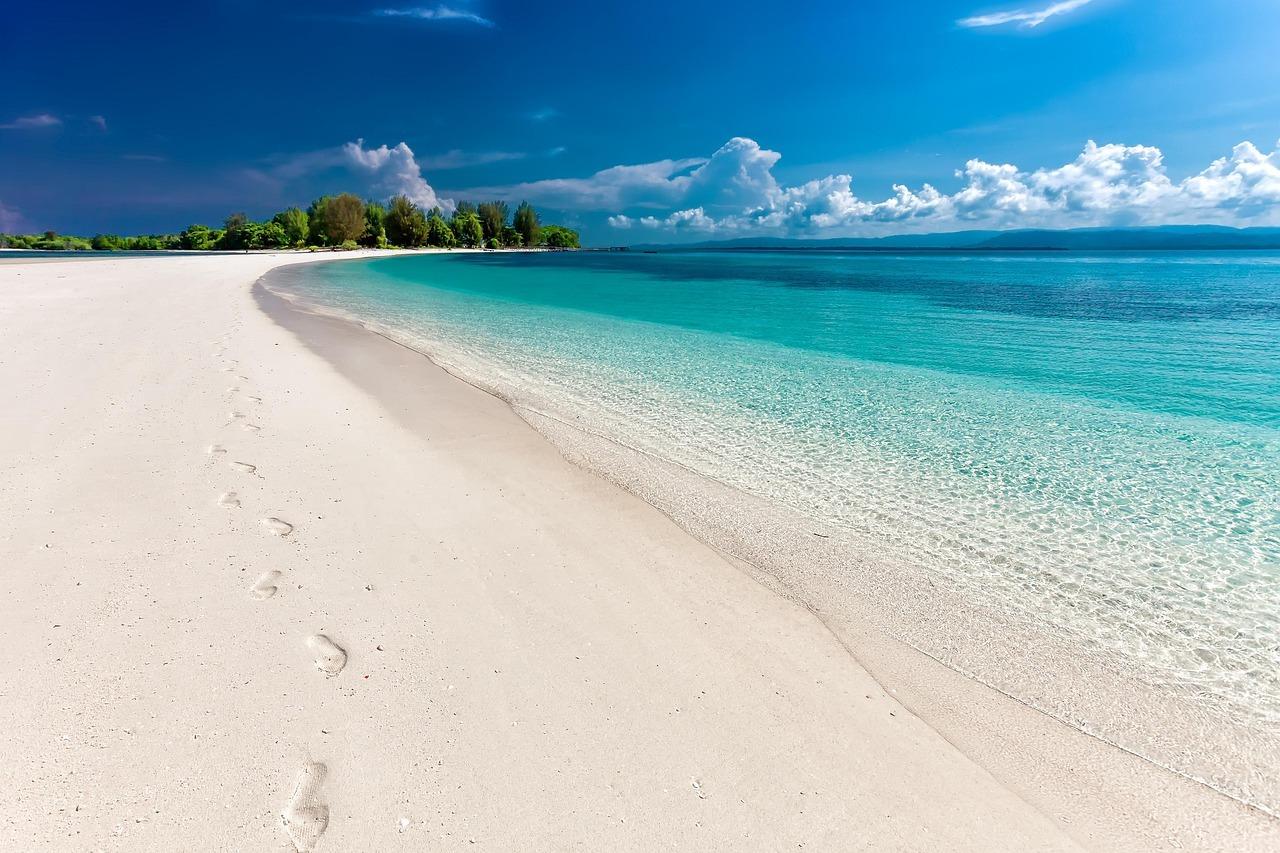 Biała piaszczysta plaża, krystaliczna turkusowa woda, tropikalny raj.