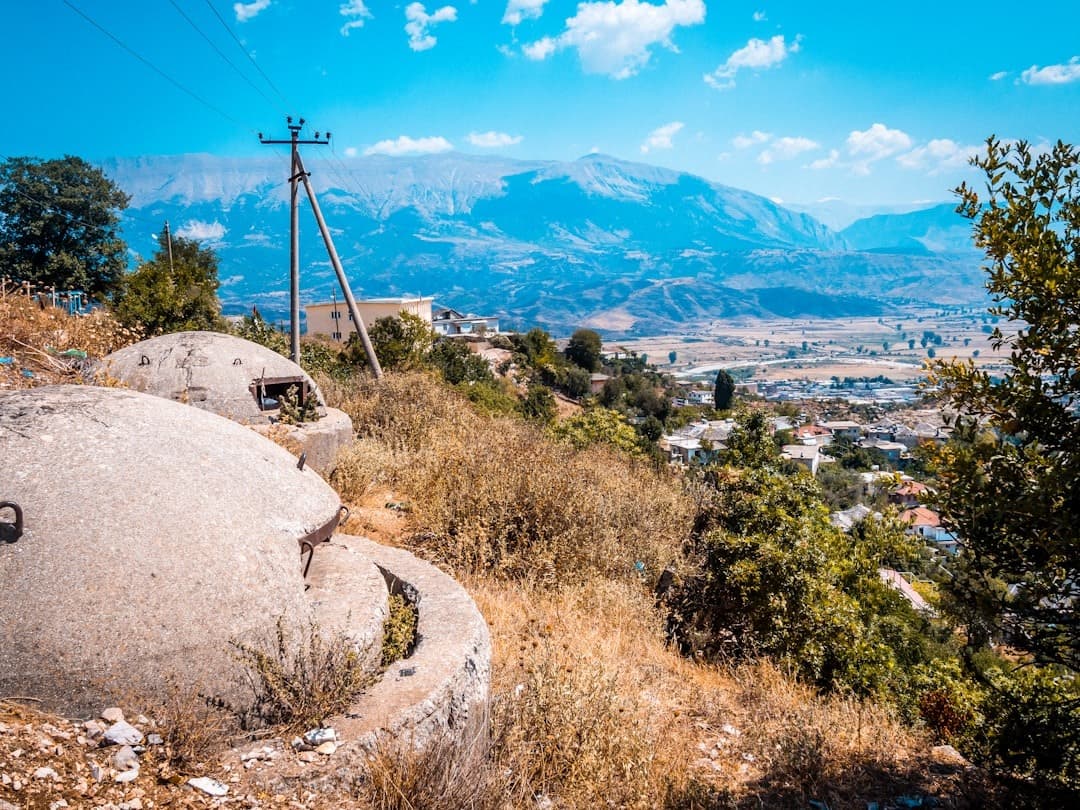 Betonowe bunkry na wzgórzu, panoramiczny widok na dolinę i góry.