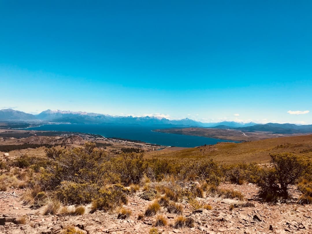 Górski krajobraz z błękitnym jeziorem i ośnieżonymi górami.