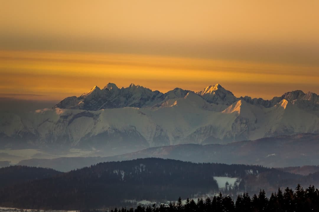 Malowniczy widok na ośnieżone Tatry o zachodzie słońca.