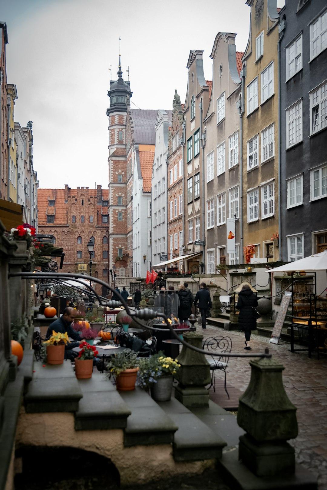 Gdańsk Stare Miasto, brukowana ulica, kolorowe kamienice, jesienna kawiarnia.