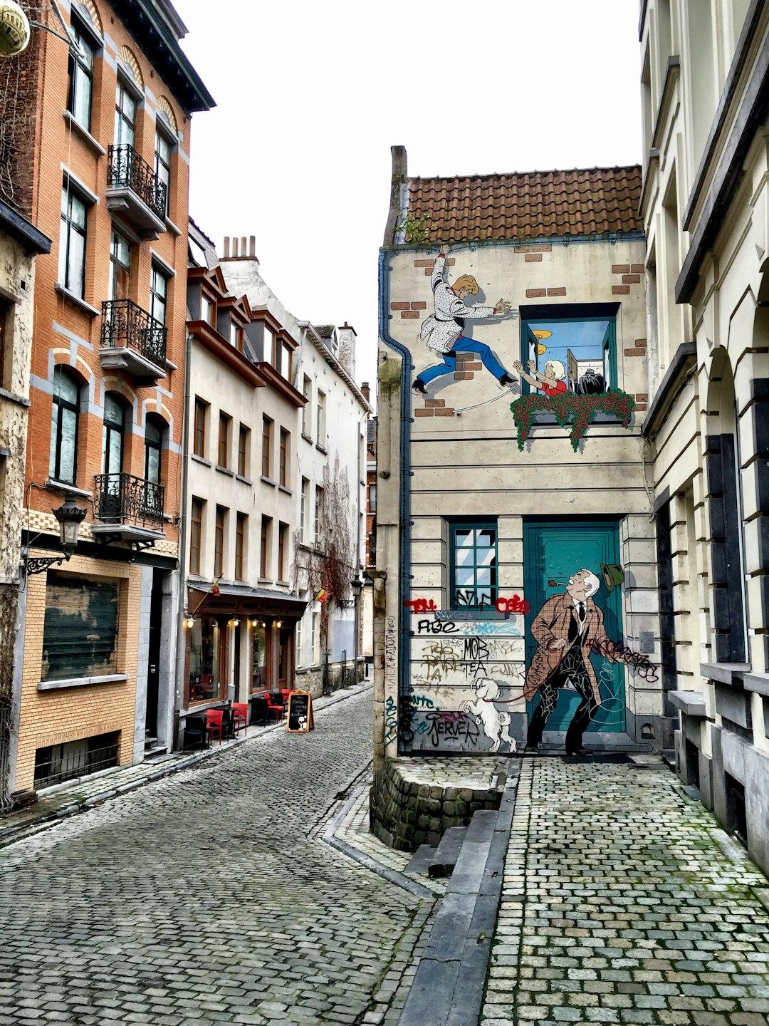 Brukowana ulica z muralem postaci z komiksów Tintina w Brukseli.