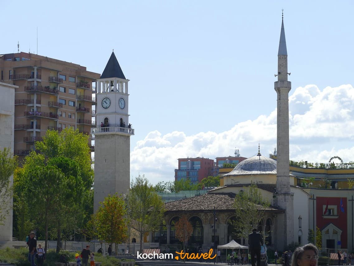 Tirana, Albania: Wieża zegarowa, meczet, minaret na słonecznym placu miejskim.
