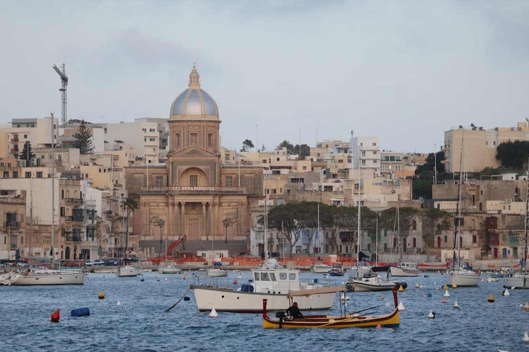 Widok na port Senglea, Malta, z zabytkowym kościołem i łodziami.