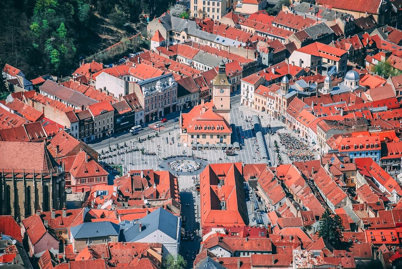Panoramiczny widok starego miasta z czerwonymi dachami i rynkiem.