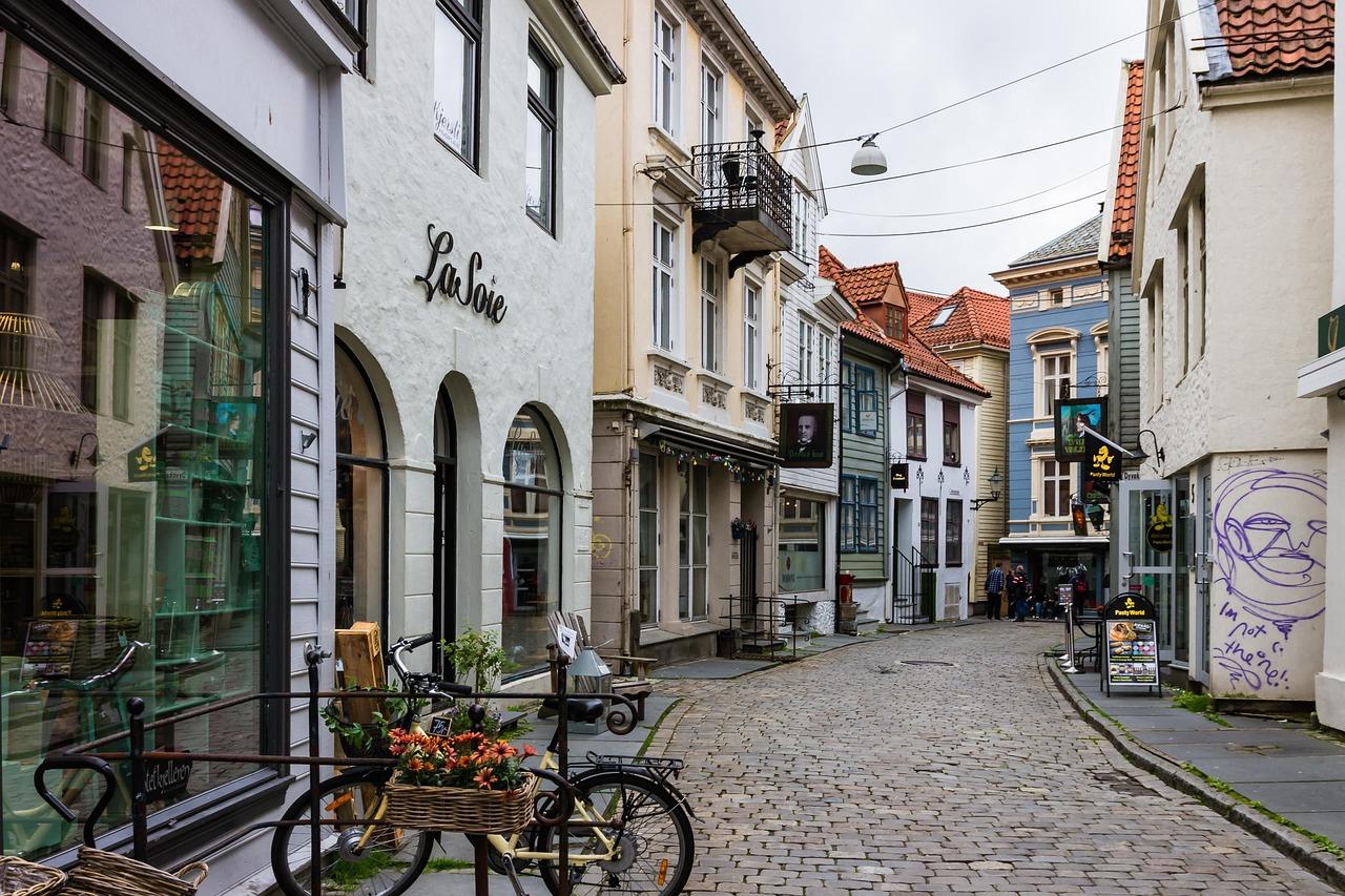 Brukowana ulica w Bergen, kolorowe kamienice, sklep La Soie, rowery.
