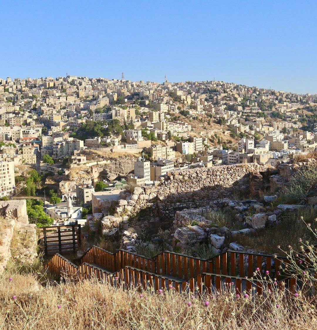 Gęsto zabudowane miasto Amman na wzgórzach, starożytne ruiny i schody.