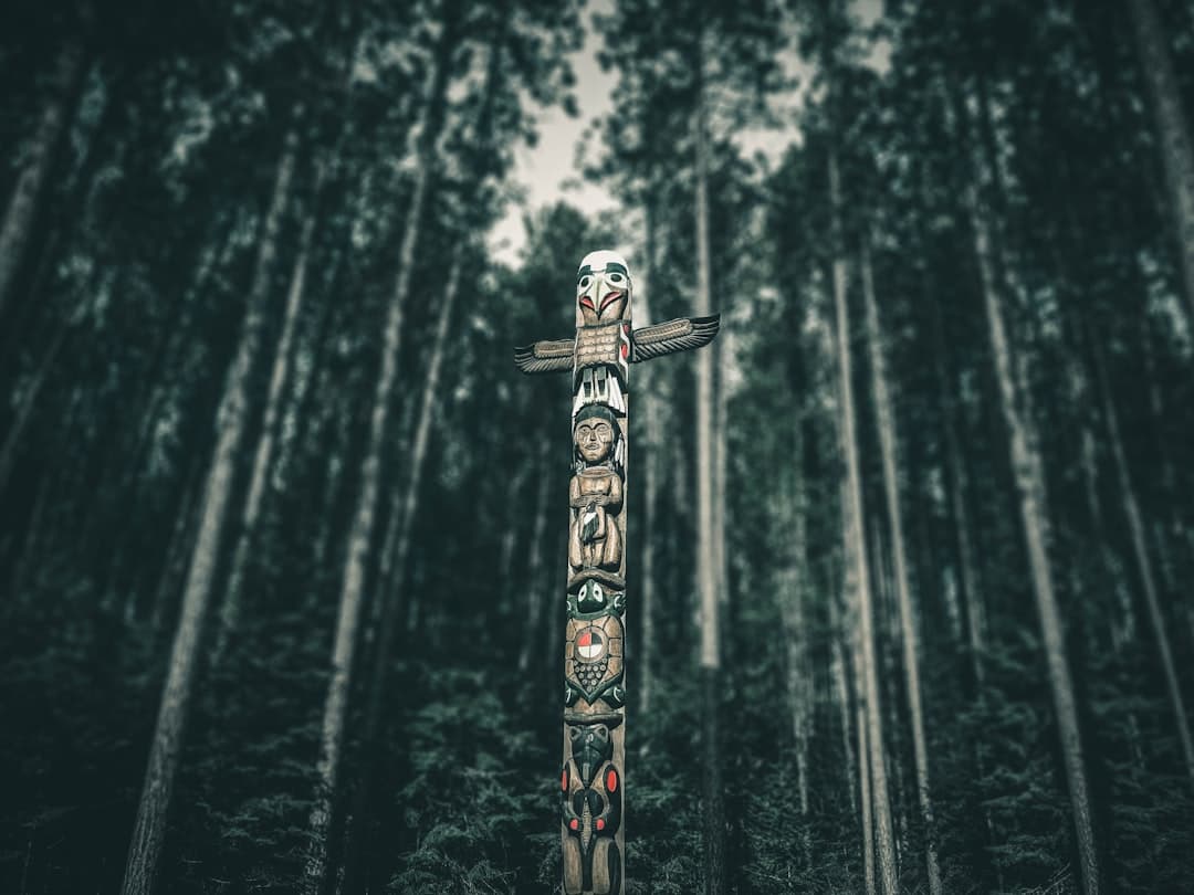 Wysoki, ozdobny totem plemienny w głębokim lesie iglastym.