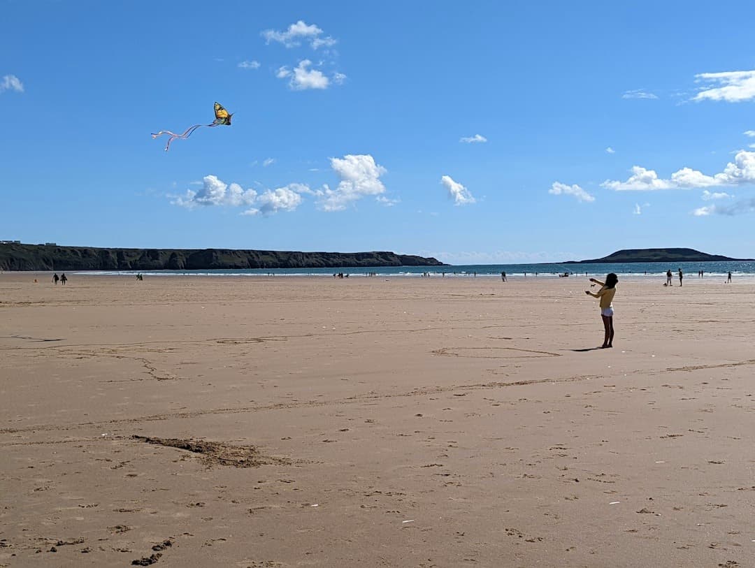 Osoba puszcza kolorowy latawiec na słonecznej piaszczystej plaży.