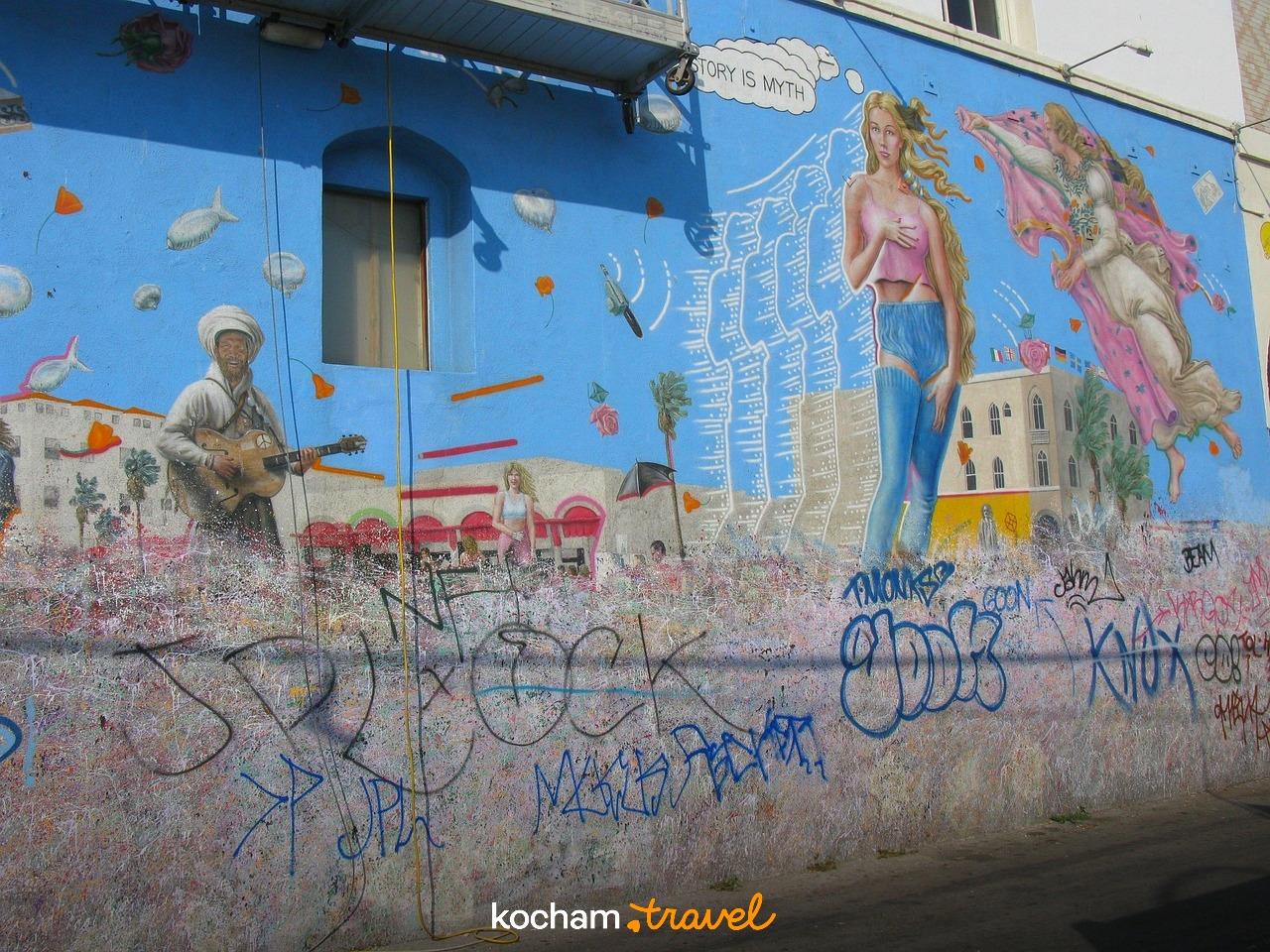 Kolorowy mural z postaciami i graffiti na miejskiej ścianie budynku