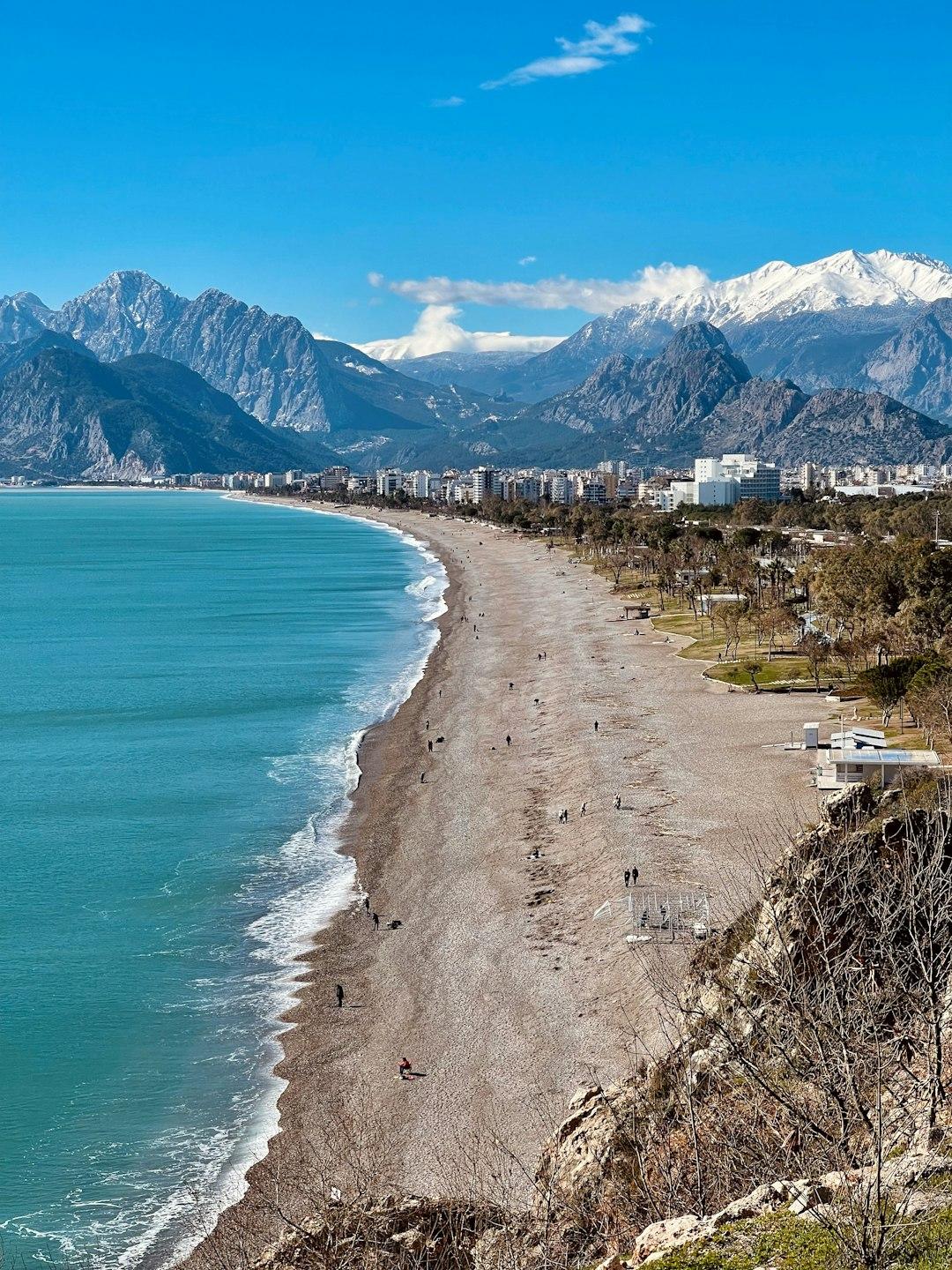 Widok na plażę Konyaaltı, morze, miasto i ośnieżone góry Taurus.