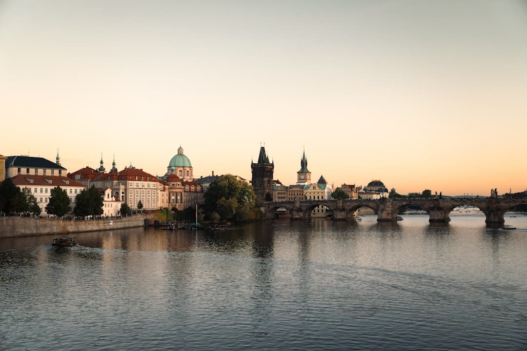 Panorama Pragi: Most Karola, Wełtawa i zabytkowe budynki o zachodzie słońca.