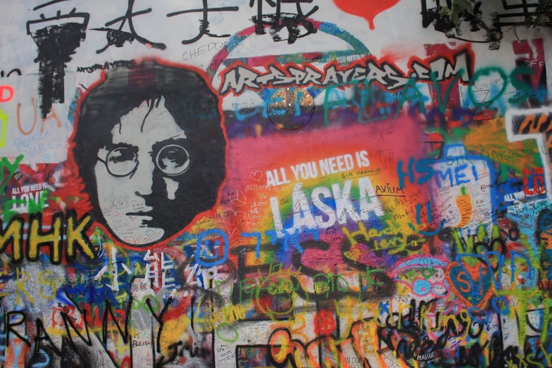 Kolorowe graffiti na Murze Johna Lennona w Pradze z jego portretem.