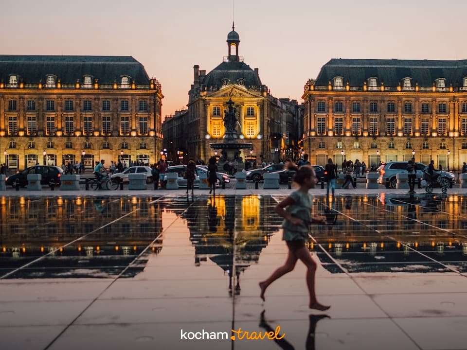 Dziecko biegnące po lustrze wody, Bordeaux, Place de la Bourse, odbicia zachodu słońca.
